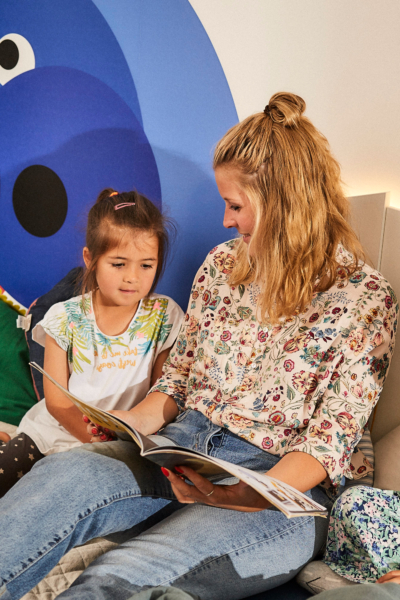 Frau ließt Kind ein Buch vor.