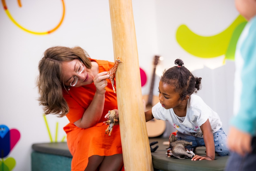 Eine Pädagogin zeigt einem Kind eine Giraffe in der Kita kinderzimmer Hamburg
