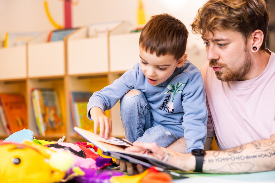 Pädagoge liest einem Jungen aus Buch vor
