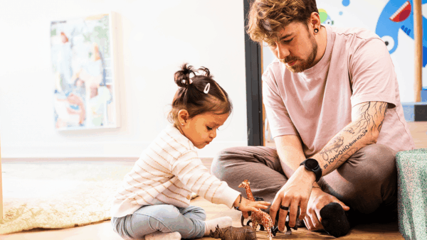 Ein Krippenkind spielt mit einem Erzieher in der Kita kinderzimmer Hamburg