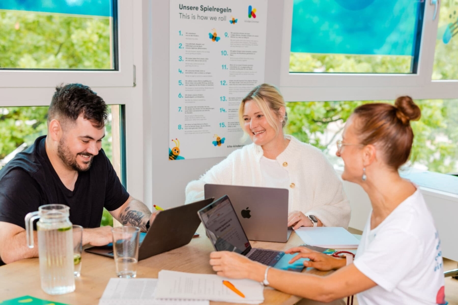 3 Kitaleitungen sitzen gemeinsam am Tisch und besprechen sich in der Kita kinderzimmer Hamburg