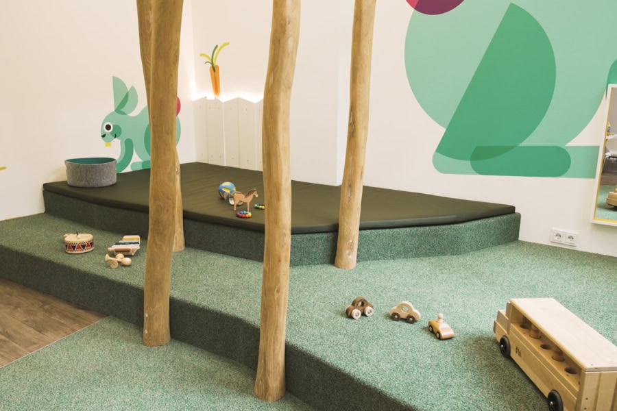 Krippenraum mit Kletterpodest und Baumstämmen in der Kita kinderzimmer am Stadtpark in Hamburg